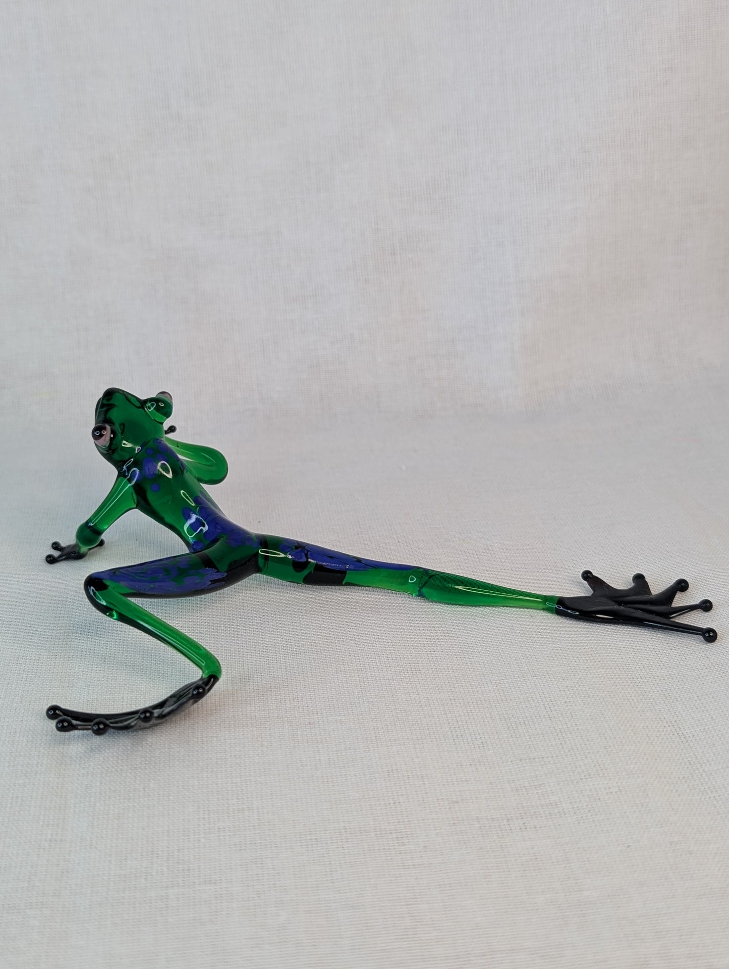 A green frog crawls .